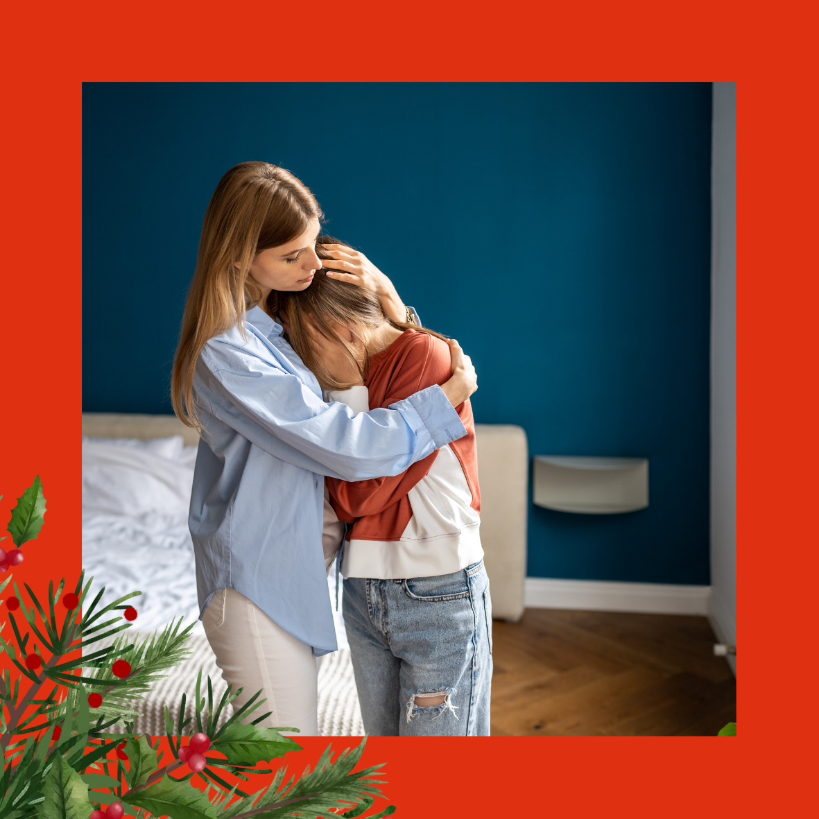 An image of a woman hugging a child who has their head in their hands and is covering their face. The image is on a red background and has holly and berries in the left-hand corner. 