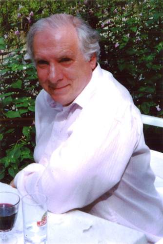 An image of Selwyn Goldsmith, a man in a white shirt with white hair and a smile 