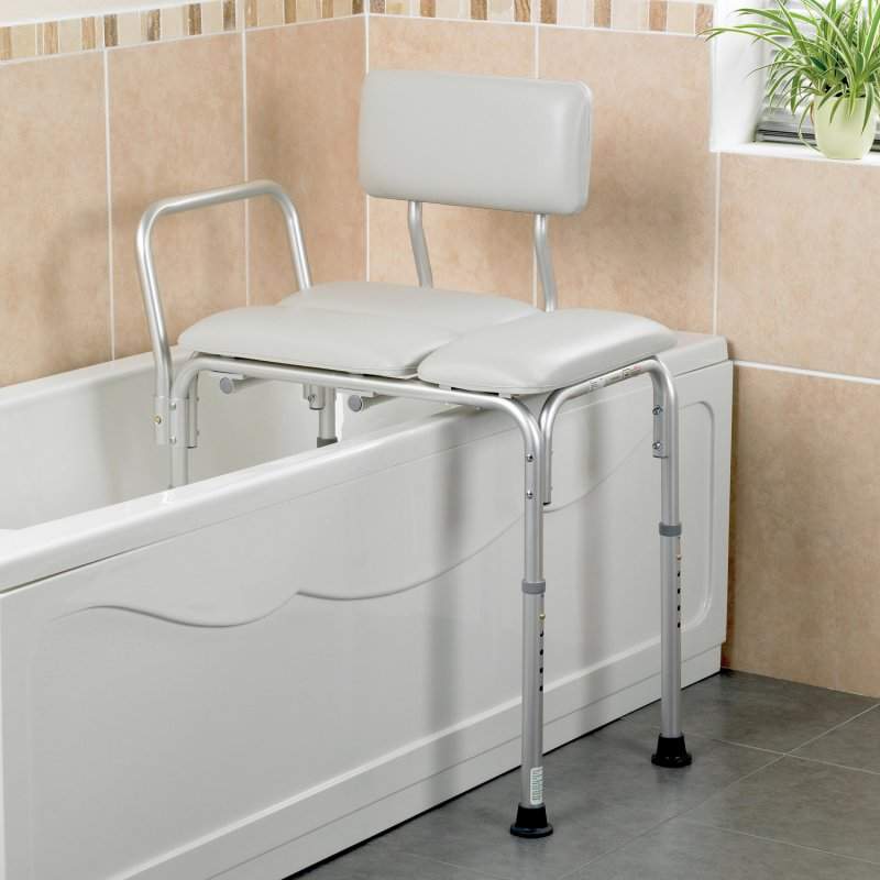 An image of a white cushions transferring bath bench. It has metal adjustable legs and a metal handle.