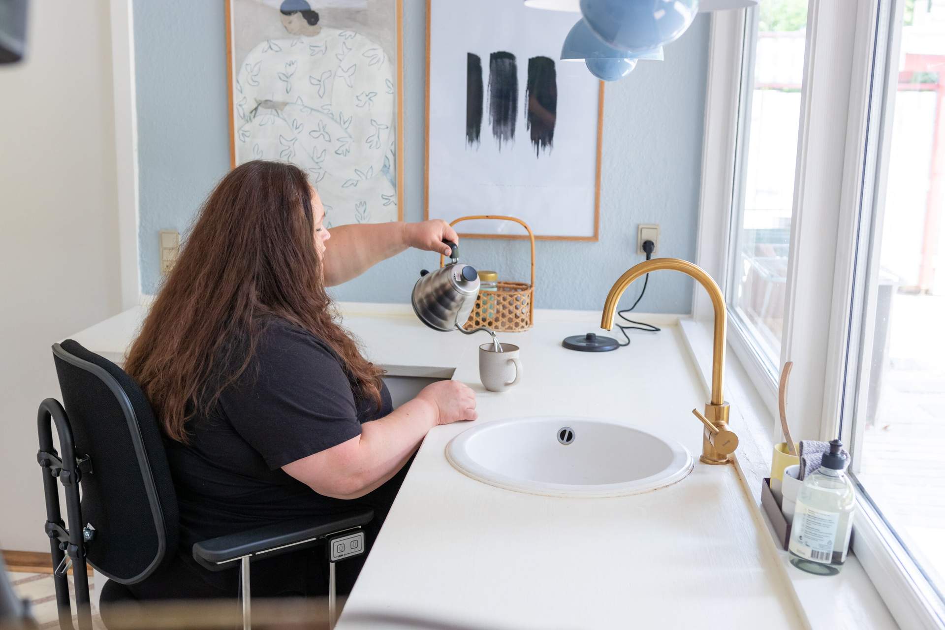Woman using a VELA bariatric chair in the kitchen