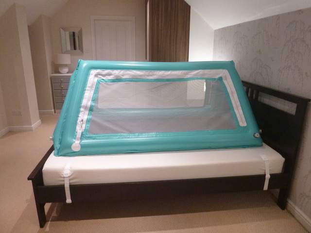 Safe place bed inflated with side door zipped up on top of regular bed