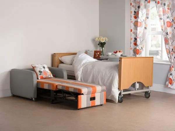 Stargazer foldable chair bed in bed position next to a medical bed