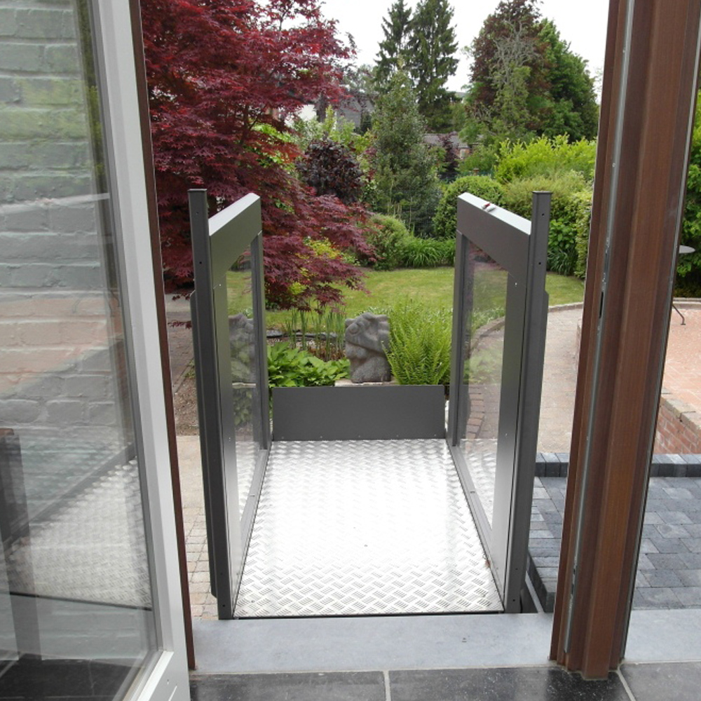 Open platform lift in doorway opening onto garden.