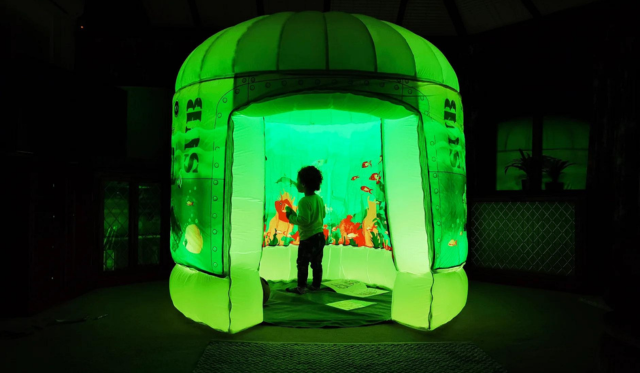 Child playing in Submarine themed pod with green lighting