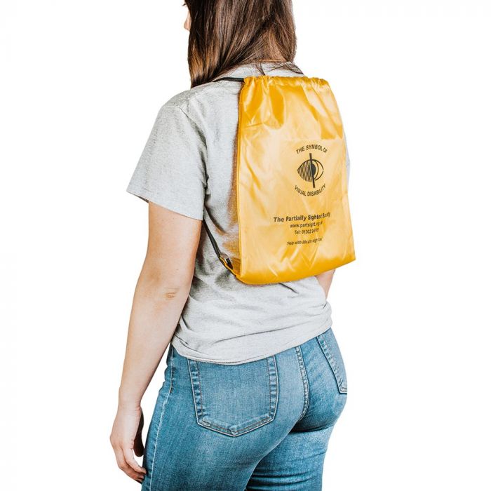 Person wearing yellow plastic rucksack with black drawstrings. The Symbol of partially sighted society in centre