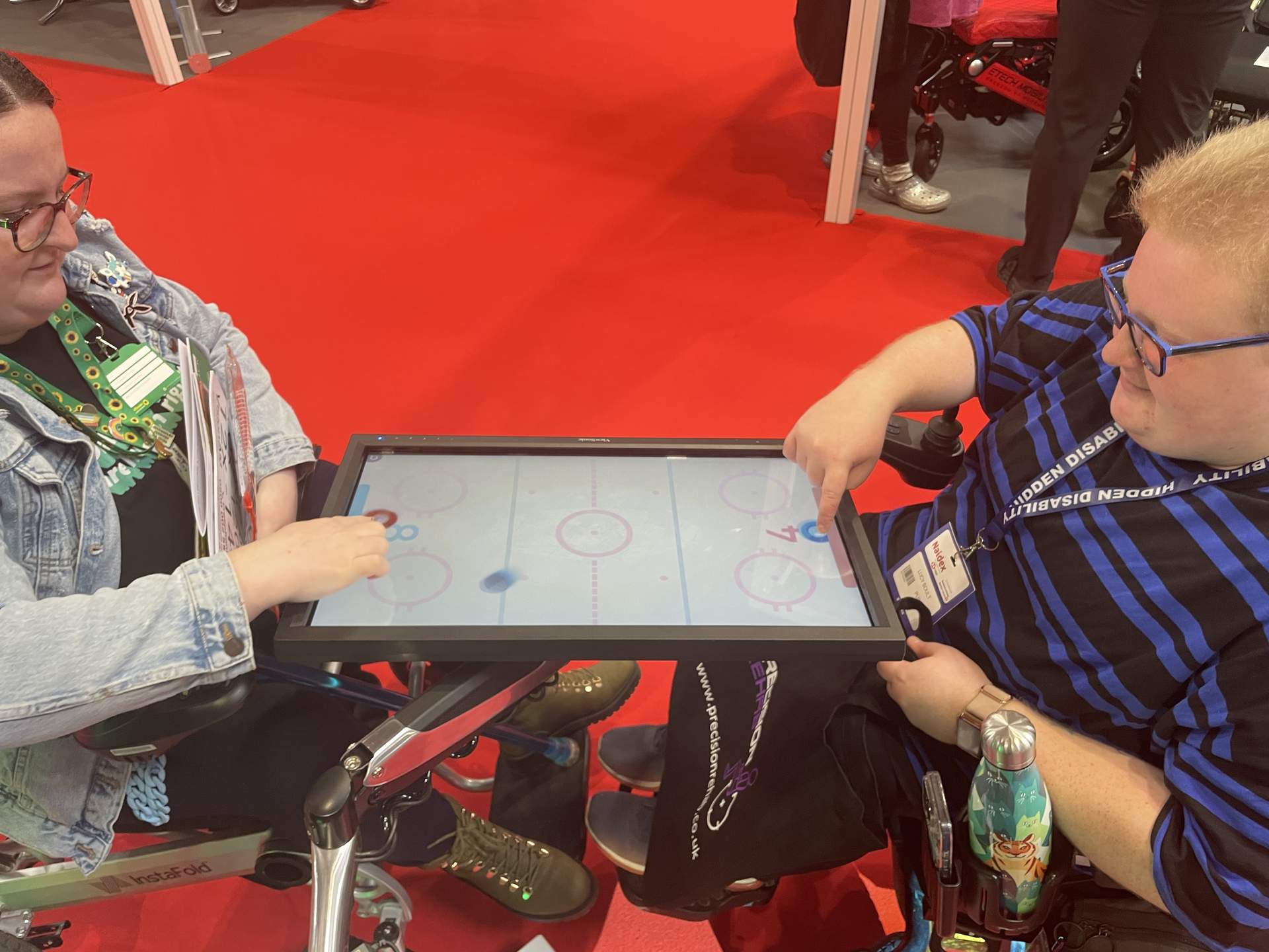 The Serene Interactive screen being used by two adults in wheelchairs, in a table position